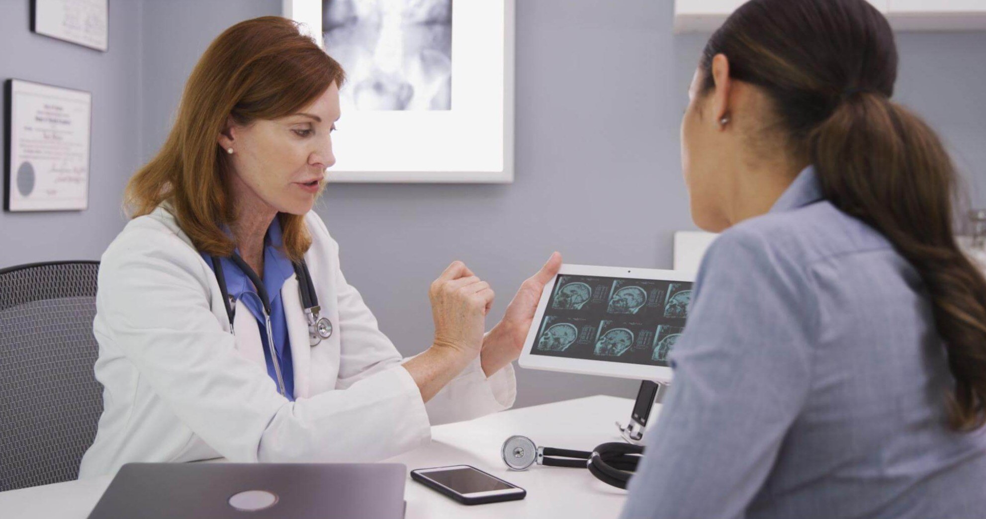 A woman is consulting with her doctor regarding her brain injury