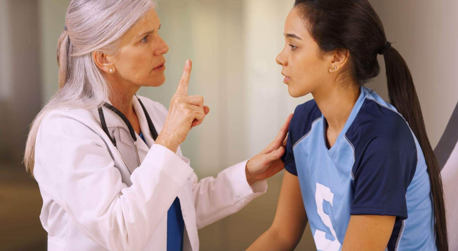 A doctor evaluates an athlete after a clash on the soccer field